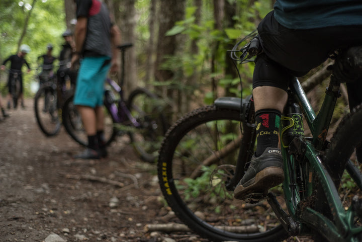Mountain bike riders on trail with Bike Co socks on.